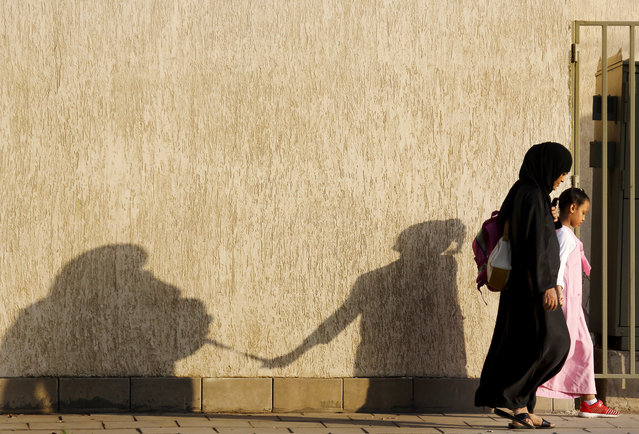 The shadow of mother and her daughter is reflected on a wall as they walk to the school, in Jiddah, Saudi Arabia, Monday, October 21, 2019. (Photo by Amr Nabil/AP Photo)