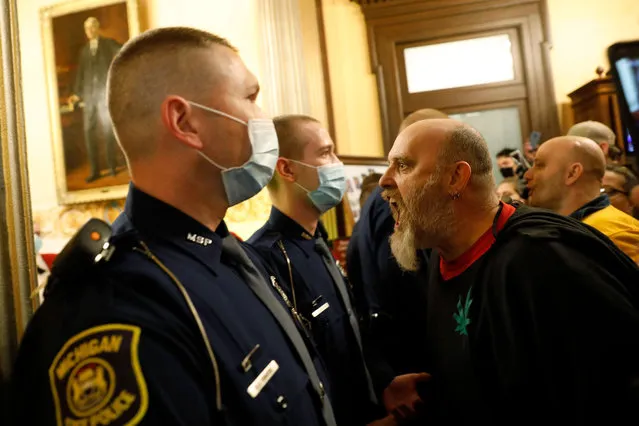 Protestors try to enter the Michigan House of Representative chamber and are being kept out by the Michigan State Police after the American Patriot Rally organized by Michigan United for Liberty protest for the reopening of businesses on the steps of the Michigan State Capitol in Lansing, Michigan on April 30, 2020. The group is upset with Michigan Gov. Gretchen Whitmer's mandatory closure to curtail Covid-19. (Photo by Jeff Kowalsky/AFP Photo)