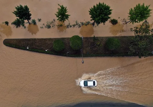 A car is driven through floodwaters in Gyeongju, South Korea, after Typhoon Hinnamnor on Tuesday, September 6, 2022. South Korea on Tuesday was hit by heavy rain and strong winds but avoided the extensive destruction that many had feared as Typhoon Hinnamnor made its way out to sea faster than forecasters had expected. (Photo by Chang W. Lee/The New York Times)