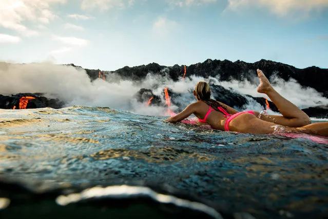 Alison Teal paddles out to Kilauea volcano in Hawaii as it eruopts into the ocean. (Photo by Perrin James/Caters News)