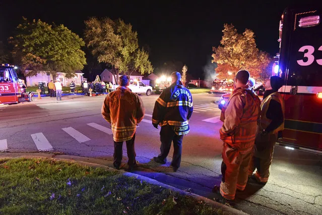 First responders work around a manhole to rescue a man who is trapped underground in Streamwood, Ill., Wednesday, October 25, 2017. The Daily Herald reports firefighters worked roughly four hours Wednesday night to pull a worker out of a manhole in Streamwood. Firefighters did not realize he was dead until after he was pulled from the manhole. (Photo by John Starks/Daily Herald via AP Photo)