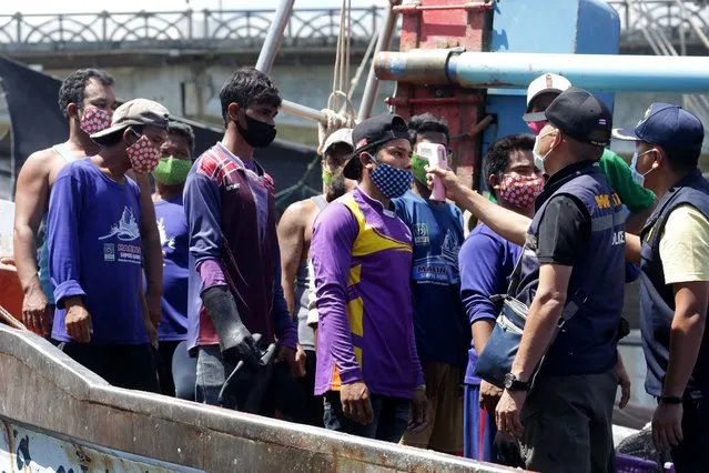 Immigration officers check the temperatures of Myanmar fisherman, as a preventive measure against the spread of the COVID-19 novel coronavirus, at the port in Pattani on April 11, 2020. (Photo by Tuwaedaniya Meringing/AFP Photo)