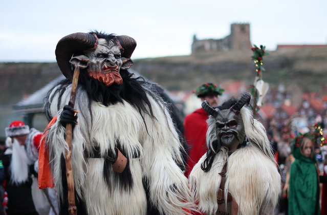 People dressed as characters from folklore parade through the streets during the annual Krampus Run in Whitby, Britain on December 2, 2023. The annual costumed parade interprets the Alpine folklore legend of the Krampus, a horned demon who punishes naughty children during the Christmas season. (Photo by Adam Vaughan/EPA/EFE)