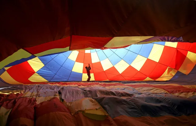 A man prepares a hot air balloon during the 2nd Hot Air Balloon Carnival in Nanjing, Jiangsu province, China October 28, 2017. (Photo by Reuters/China Stringer Network)