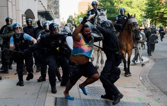 Riot police chase a man as they rush protestors to clear Lafayette Park and the area around it across from the White House for President Donald Trump to be able to walk through for a photo opportunity in front of St. John's Episcopal Church in Washington, June 1, 2020. (Photo by Ken Cedeno/Reuters)