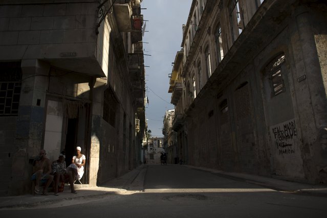 A woman dressed in white in accordance with the Afro-Cuban religion Santeria sits at her doorstep in downtown Havana, August 28, 2015. (Photo by Alexandre Meneghini/Reuters)