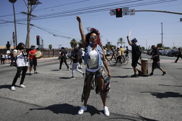 A protester raises her fist during a march in honor of Andres Guardado on Sunday, June 21, 2020, in Compton, Calif. Guardado was shot Thursday after Los Angeles County sheriff's deputies spotted him with a gun in front of a business near Gardena. (Photo by Marcio Jose Sanchez/AP Photo)