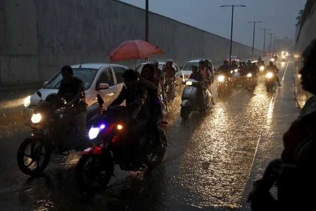 Commuters on their vehicles move through an underpass during a heavy rain shower in Ahmedabad, India, September 18, 2015. Rains were 16 percent below average so far over the four-month monsoon season that ends this month due to an El Nino weather pattern, which can lead to scorching weather across Asia and east Africa but heavy rains and floods in South America. (Photo by Amit Dave/Reuters)