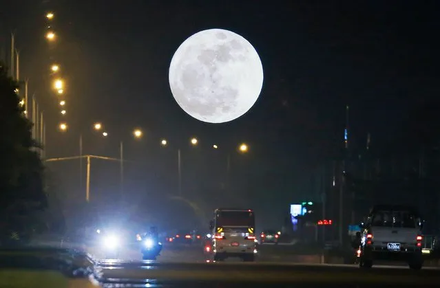 A so-called “Supermoon” dominates the sky while traffic rolls in the streets in Naypyitaw, Myanmar, 03 December 2017. According to the National Aeronautics and Space Administration (NASA) a series of three “Supermoons” – dubbed the “Supermoon trilogy” – will appear in the sky on 03 December 2017, on 01 January 2018 and and 31 January 2018. A 'Supermoon' commonly is a full moon at its closest distance to the earth with the moon appearing larger than usual. (Photo by Hein Htet/EPA/EFE)