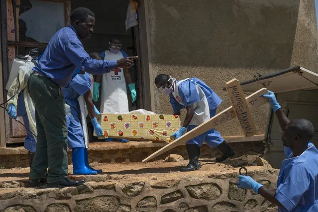 In this Sunday, July 14, 2019 file photo, Red Cross workers carry the remains of 16-month-old Muhindo Kakinire, who died of Ebola, from the morgue into a truck as health workers disinfect the area in Beni, Congo. The World Health Organization on Thursday, June 25, 2020, has declared an end to the second deadliest Ebola outbreak in history, that killed 2,280 people over nearly two years. (Photo by Jerome Delay/AP Photo/File)