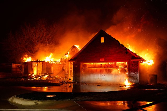 Fire burns residences during a wildfire outbreak in Stillwater, Oklahoma, on March 14, 2025. (Photo by Nick Oxford/Reuters)