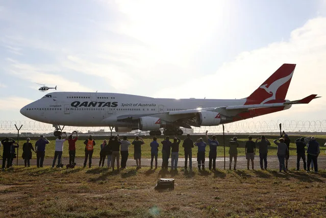 People watch the last Qantas 747 jet depart Sydney Airport in Sydney, Australia, as Qantas retires its remaining Boeing 747 planes early due to the coronavirus disease (COVID-19) outbreak, July 22, 2020. (Photo by Loren Elliott/Reuters)
