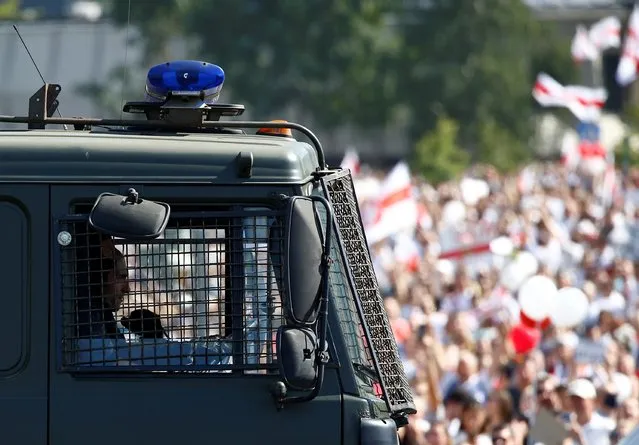 Belarusian law enforcement officers are seen inside a vehicle during a protest against the presidential election results demanding the resignation of Belarusian President Alexander Lukashenko and the release of political prisoners, in Minsk, Belarus on August 16, 2020. (Photo by Vasily Fedosenko/Reuters)