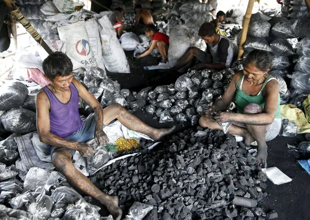 Workers repack charcoal used for cooking at a retailers shop in Las Pinas, Metro Manila October 6, 2015. (Photo by Erik De Castro/Reuters)