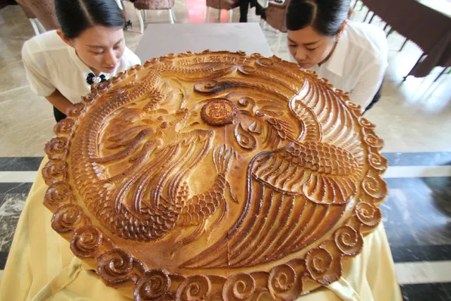Staff pose with a giant moon cake ahead of China's Mid Autumn Festival in Binzhou, Shandong Province, China, September 10, 2016. (Photo by Reuters/Stringer)