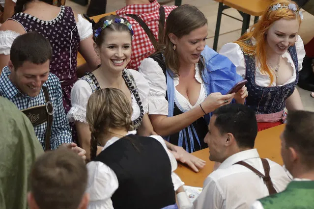 A young woman dressed in traditional clothes smiles after entering a tent prior to the opening of the 183rd Oktoberfest beer festival in Munich, southern Germany, Saturday, September 16, 2016. The world's largest beer festival will be held from Sept. 16 to Oct. 3, 2016. (Photo by Matthias Schrader/AP Photo)