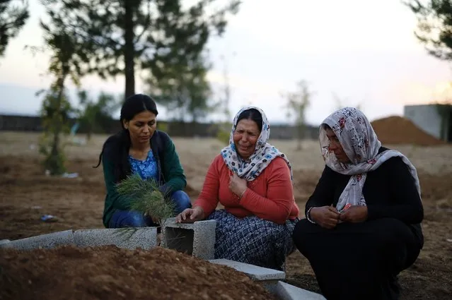 Women mourn near graves of Kurdish fighters who died in Kobani, near the southeastern town of Suruc in Sanliurfa province, on the Turkish-Syrian border in this October 15, 2014 file photo. (Photo by Kai Pfaffenbach/Reuters)