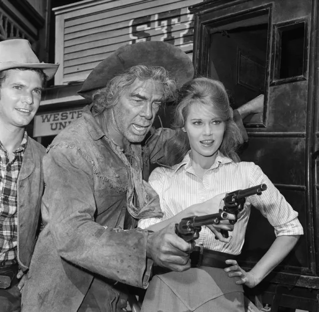 Actress Jane Fonda gets some tips on how to handle a six-shooter from Veteran Actor Lee Marvin during a break in the shooting of the movie, “Cat Ballou” on October 26, 1964 in Hollywood, Los Angeles. It's the first Western for Jane. (Photo by AP Photo/DAB)