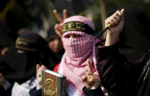 A Palestinian woman supporting the Islamic Jihad movement holds a copy of the Koran as another holds a knife during a rally in Gaza City to show solidarity with Palestinians confronting Israelis in the West Bank and Jerusalem October 20, 2015. (Photo by Mohammed Salem/Reuters)