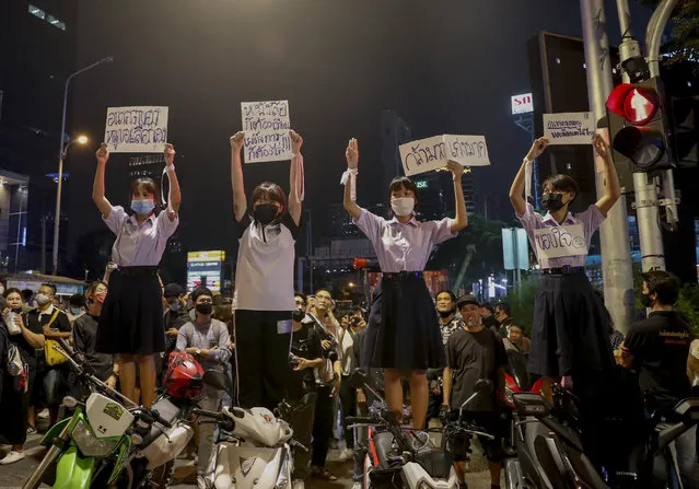 School children and supporters of pro-democracy protesters, display placards during a rally at a major intersection next to the German Embassy in central Bangkok, Thailand Monday, October 26, 2020. As lawmakers debated in a special session in Parliament that was called to address political tensions, the students-led rallies were set to continue with a march through central Bangkok Monday evening to the German Embassy, apparently to bring attention to the time King Maha Vajiralongkprn spends in Germany. Placards from left read: “My future, can I choose it by myself, Have to study and disperse dictatorship at the same time, very brave, very good, Thank you”. (Photo by Gemunu Amarasinghe/AP Photo)