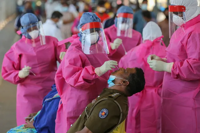 A Sri Lankan Police officer undergoes a Covid-19 swab test at a bus terminal amid the coronavirus pandemic in Colombo, Sri Lanka, 09 November 2020. The Sri Lankan government announced to ease the quarantine curfew in the capital Colombo and some parts of the country according to the 'new normal' to restart economic activities amidst of  Coronavirus pandemic. The government imposed a quarantine curfew in some parts of the country about a month ago following the sudden spike of the Covid-19 clusters from a textile factory and a fish market in Western Province. (Photo by Chamila Karunarathne/EPA/EFE)
