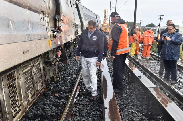 In this October 9, 2016 handout photo provided by the office of New York Governor Andrew Cuomo, shows Governor Cuomo and MTA Chairman Tom Pendergast(R) inspecting a Long Island Rail Road train that derailed and collided with a work train late October 8, along the mainline in New Hyde Park, New York. The LIRR train was heading eastbound on the mainline when the first three cars of a 12-car train derailed about one half mile east of the New Hyde Park Station. A New York commuter train derailed outside the city late Saturday, authorities said, without immediately confirming reports that dozens have minor injuries. “The 9:22PM train from Penn due Huntington at 10:28PM has been canceled due to a train derailment near New Hyde Park”, the Long Island Rail Road (LIRR) said on Twitter. According to the governor's office  of the approximately 600 passengers on board at the time of the incident, 33 people sustained injuries, none of which were considered to be life-threatening. (Photo by Kevin P. Coughlin/AFP Photo/Office of Governor Andrew M. Cuomo)