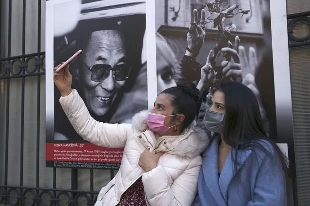 Women wearing masks to help protect against the spread of coronavirus, take a selfie, in Ankara, Turkey, Monday, November 30, 2020.Turkey's President Recep Tayyip Erdogan has announced Monday the most widespread lockdown so far amid a surge in COVID-19 infections, extending curfews to weeknights and full lockdowns over weekends. (Photo by Burhan Ozbilici/AP Photo)