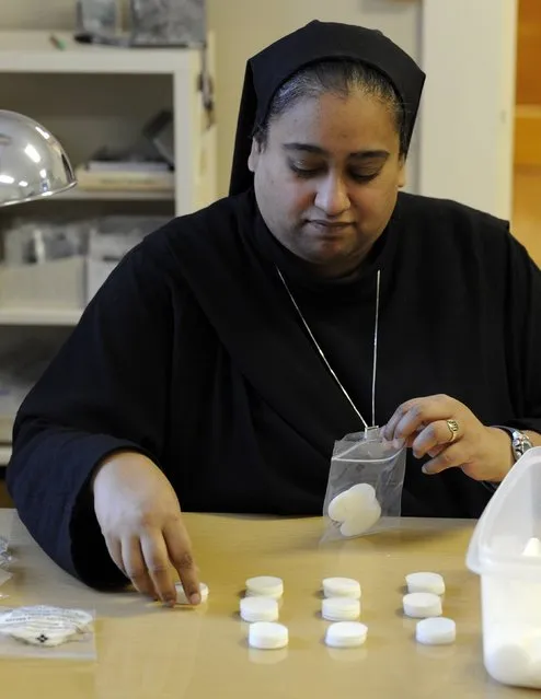 Altar Bread Manager Sister Lynn Marie D'Souza, who has a degree in biomedical sciences from Texas A&M, packages low-gluten wafers at the Benedictine Sisters of Perpetual Adoration monastery in Clyde, Missouri, December 18, 2014. (Photo by Dave Kaup/Reuters)
