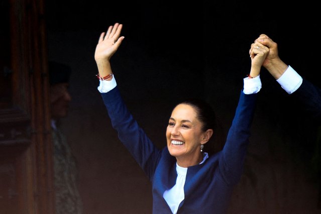 Mexican President-elect Claudia Sheinbaum raises her hands with Mexico's President Andres Manuel Lopez Obrador as she arrives to hold a press conference at Palacio Nacional in Mexico City on June 10, 2024. (Photo by Raquel Cunha/Reuters)