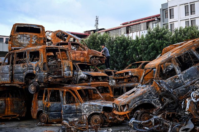 A man looks at charred vehicles inside the torched Parliament building complex in Kathmandu on October 8, 2025. (Photo by Prakash Mathema/AFP Photo)