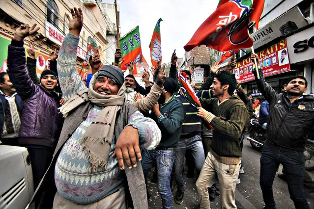 Bharatiya Janata Party (BJP) supporters dance to celebrate the news of early election result trends outside their party headquarters in Jammu, India, Tuesday, December 23, 2014. India's ruling Hindu nationalist Bharatiya Janta Party is poised to emerge as an important political player in the disputed Himalayan region of Kashmir, as votes in local elections are being counted. (Photo by Channi Anand/AP Photo)