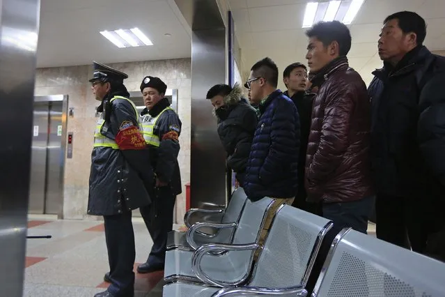 Security guards stand in front of family members as they wait at a hospital after a stampede during a New Year's celebration on the Bund, a waterfront area in central Shanghai January 1, 2015. (Photo by Aly Song/Reuters)