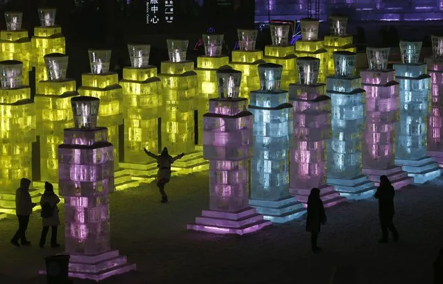 People visit ice sculptures illuminated by coloured lights during a trial operation ahead of the 31st Harbin International Ice and Snow Festival in the northern city of Harbin, Heilongjiang province, January 4, 2015. (Photo by Kim Kyung-Hoon/Reuters)