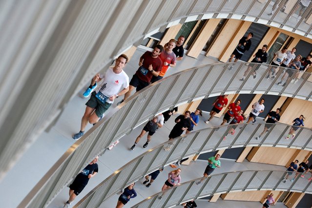 Runners climb the ramp during the Vortex Race, created by students inside the Vortex, an eight-storey circular building with a 2.8-kilometre helicoidal ramp with a 1% incline housing 941 rooms for the University of Lausanne, in Chavannes-près-Renens, Switzerland, on October 16, 2025. (Photo by Stefan Wermuth/Reuters)