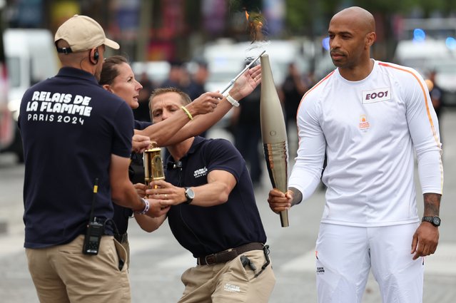Thierry Henry holds the Paris 2024 Olympic flame as the Olympic Torch Relay arrives in Paris, France, 14 July 2024. The Olympic torch relay arrived in Paris on Bastille Day, the country's national holiday, and will visit some of the city's most famous landmarks on 14 and 15 July. In May 2024, the Olympic flame began its journey across France, including five overseas regions, visiting hundreds of towns and cities before the Olympic Games Opening Ceremony on 26 July. (Photo by Julien Mattia/EPA/EFE)