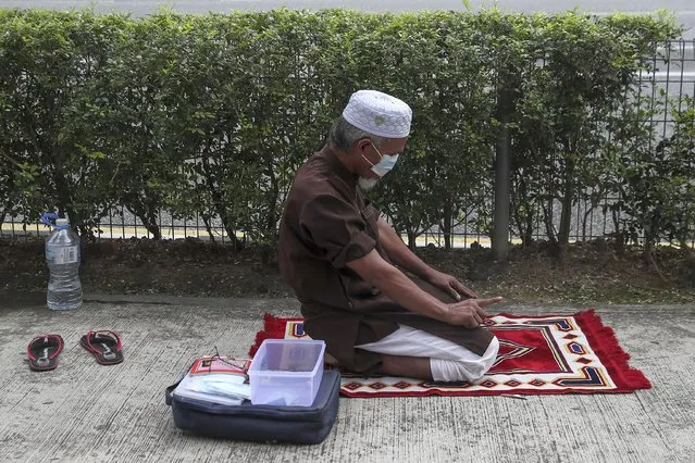 A Muslim man prays on a roadside in Kuala Lumpur, Malaysia, 12 January 2021. According to media reports on 12 January, the King of Malaysia declared a state of emergency in the country in an attempt to halt the spread of the coronavirus disease (COVID-19) pandemic. The state of emergency will last until 01 August, but can be lifted earlier if infection rates decrease. (Photo by Fazry Ismail/EPA/EFE)