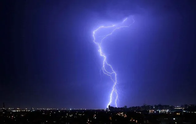 Lightning strikes in the sky over Kuwait City before a rainstorm hits the country early on October 29, 2015. (Photo by Yasser Al-Zayyat/AFP Photo)