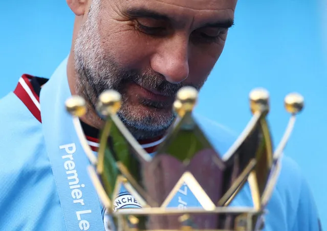 Manchester City manager Pep Guardiola celebrates with the trophy after winning the Premier League at Etihad Stadium in Manchester, Britain on May 21, 2023. (Photo by Carl Recine/Reuters)
