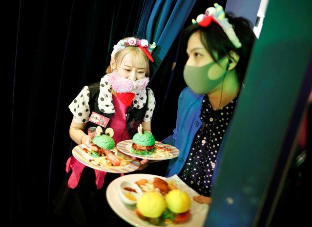 Staff members wearing protective face masks serve foods to guests at Kawaii Monster Cafe amid the coronavirus disease (COVID-19) outbreak, in Tokyo, Japan on January 31, 2021. (Photo by Issei Kato/Reuters)