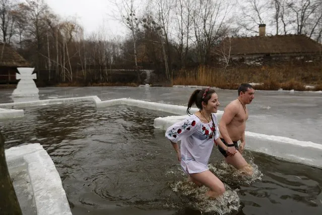 Ukrainians swim in an ice hole as part of the celebration of the Epiphany in Kiev, Ukraine, Monday, January 19, 2015. Orthodox believers celebrate the holiday of the Epiphany on Jan. 19, and traditionally bathe in holes cut through thick ice on rivers and ponds to cleanse themselves with water deemed holy for the day. (Photo by Sergei Chuzavkov/AP Photo)