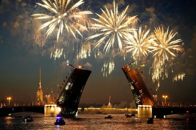 Fireworks explode over the Palace drawbridge through the Neva River during celebrations for the 320th anniversary of St. Petersburg, in St. Petersburg, Russia, early Sunday, May 28, 2023. (Photo by Dmitri Lovetsky/AP Photo)