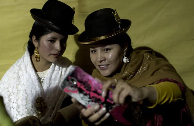 Women take pictures with their cell phone during the Miss Cholita beauty pageant in La Paz, Bolivia, Friday, June 29, 2018. (Photo by Juan Karita/AP Photo)