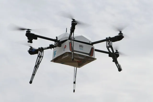 This undated handout photo received on November 16, 2016 by Domino's Pizza shows a drone designed to deliver pizzas in flight in Whangaparaoa, New Zealand. The world's first pizza drone delivery was claimed Novembr 16 by the New Zealand division of fast food giant Domino's, as it looks to grab a slice of a potentially hot future market. (Photo by AFP Photo/Domino's Pizza)