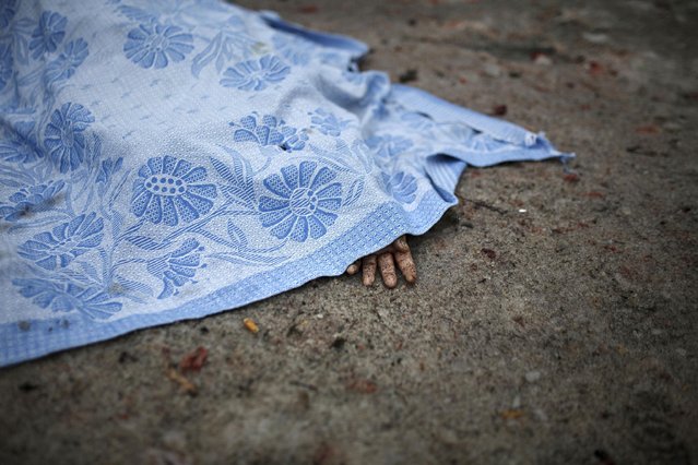 A body of a civilian killed in shelling is covered by a blanket in Donetsk, eastern Ukraine, Friday, January 30, 2015. (Photo by Vadim Braydov/AP Photo)