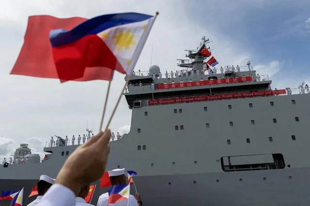 Philippine Navy personnel wave the national flags of China and the Philippines as the Chinese naval training ship “Qi Jiguang” docks at the Port of Manila for a four-day goodwill visit, in Manila, Philippines on June 14, 2023. (Photo by Eloisa Lopez/Reuters)