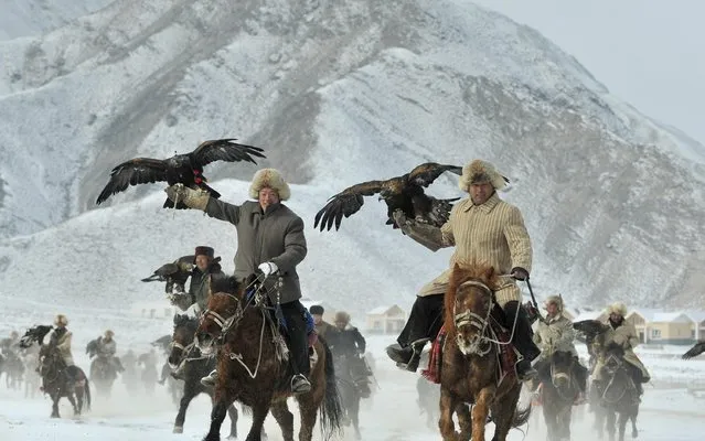 Herdsmen from the Kyrgyz ethnic group hold their falcons as they ride on horses during a hunting competition in Akqi county, Xinjiang Uighur Autonomous February 1, 2015. (Photo by Reuters/Stringer)