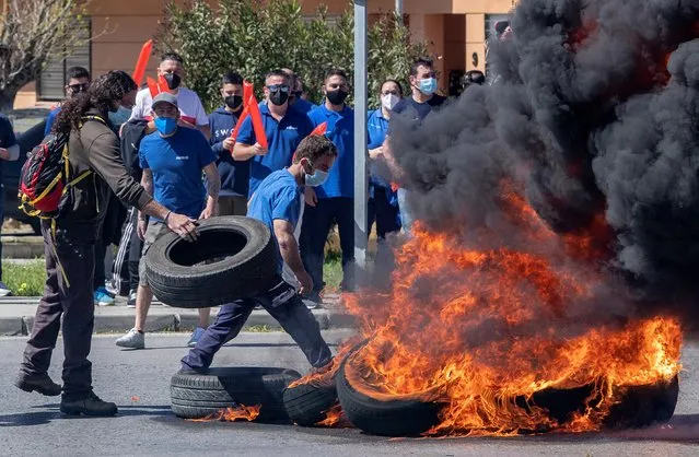 People burn tires to make a barricade during rally to demand the Airbus's plant remain open in the town of Puerto Real, in Cadiz, southern Spain, 24 March 2021. A group of some 1,000 people protested as workers try to avoid the shutting down of the plant that provides direct employment to 400 people and more than 1,000 indirect jobs. (Photo by Roman Rios/EPA/EFE)