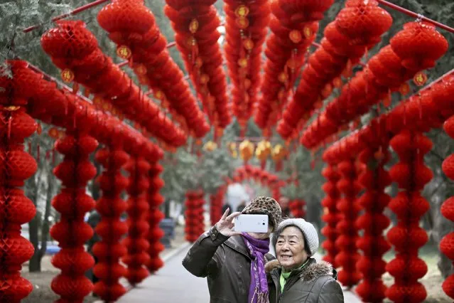 Visitors take a selfie in front of lantern decorations installed to prepare for Spring Festival celebrations in a temple fair at a park, in Beijing February 6, 2015. (Photo by Reuters/Stringer)