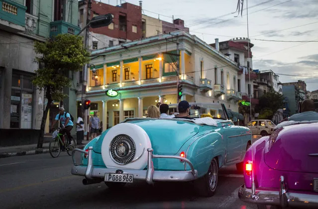 In this June 25, 2018 file photo, tourists ride classic American convertibles in Havana, Cuba. The Cuban government will allow new restaurants, bed-and-breakfasts and transportation businesses by the end of the year 2018, reopening the most vibrant sectors of the private economy after freezing growth for more than a year. (Photo by Desmond Boylan/AP Photo)