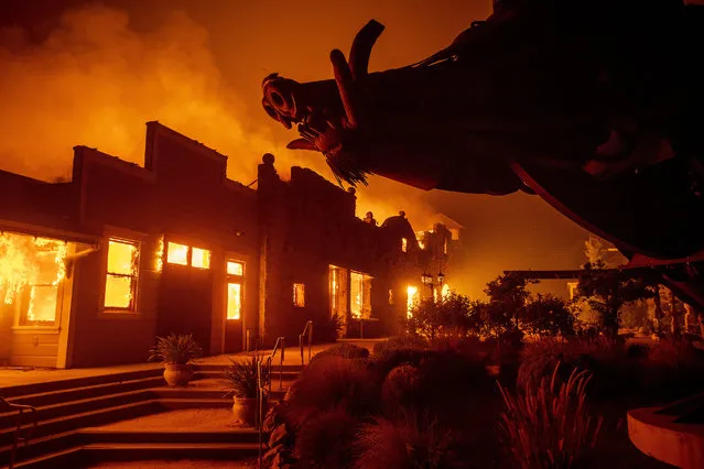 In this October 27, 2019, file photo, flames from the Kincade Fire consume Soda Rock Winery in Healdsburg, Calif. A California prosecutor has charged troubled Pacific Gas & Electric with starting a 2019 wildfire. The Sonoma County District Attorney on Tuesday April 6, 2021, charged the utility in the October 2019 Kincade Fire north of San Francisco. (Photo by Noah Berger/AP Photo/File)